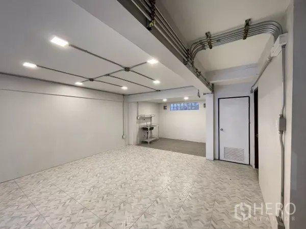 Home Office for rent in Khlong Toei, Bangkok - Bright ground-floor workspace with patterned tiles, exposed conduit ceiling and recessed lighting.
