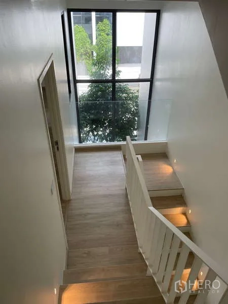 Home Office for rent in Don Mueang, Bangkok - Stair landing with floor-to-ceiling window overlooking greenery.