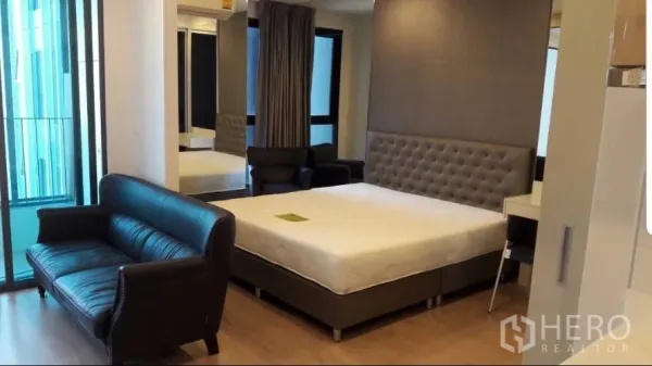 คอนโด ให้เช่าในBang Rak, Bangkok - ห้องสตูดิโอเปิดโล่ง พร้อมเตียง โซฟาหนัง และประตูเลื่อนออกสู่ระเบียง