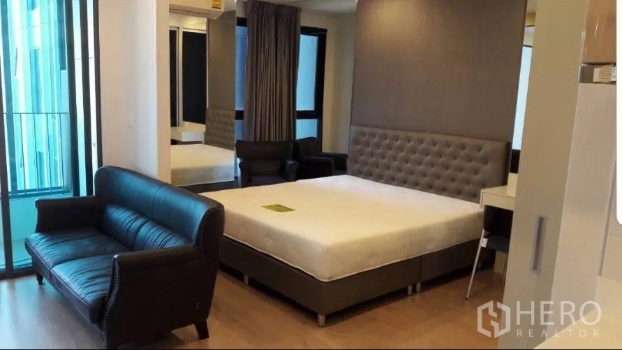 คอนโด ให้เช่าในBang Rak, Bangkok - ห้องสตูดิโอเปิดโล่ง พร้อมเตียง โซฟาหนัง และประตูเลื่อนออกสู่ระเบียง