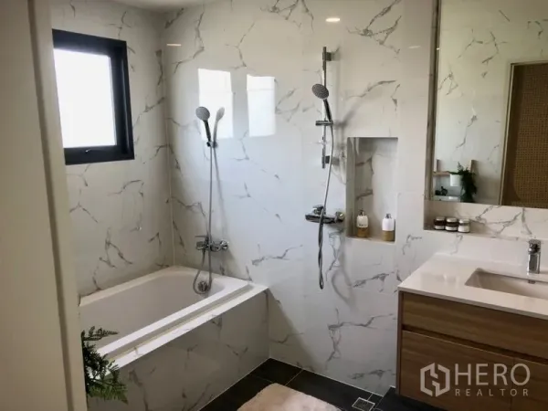 Detached House for sale - Modern bathroom with marble-effect tiles, bathtub, separate handheld shower, niche shelf and wood vanity.