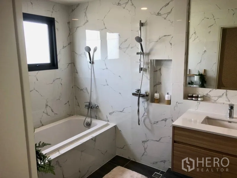 Detached House for sale - Modern bathroom with marble-effect tiles, bathtub, separate handheld shower, niche shelf and wood vanity.