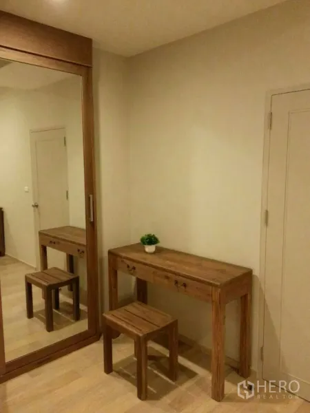 Condominium for rent or sale in Watthana, Bangkok - Bedroom dressing corner featuring mirrored wardrobe, wooden vanity desk and stool.