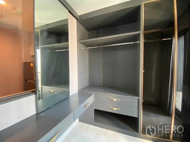 Condominium for rent in Pathum Wan, Bangkok - Corner wardrobe featuring open shelves, drawers and a mirrored door.