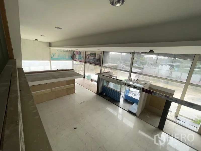 Warehouse for rent in Prawet, Bangkok - Upper floor view across showroom booths and glass facade.