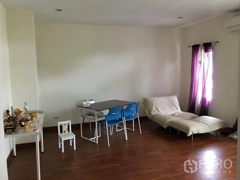 联排别墅 出售在Huai Khwang, Bangkok - 宽敞多功能房，木地板，餐桌和沙发。