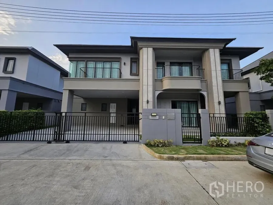 独立式住宅 出售在Mueang Pathum Thani, Pathum Thani - 两层现代独栋别墅，带阳台与前院围栏车道。