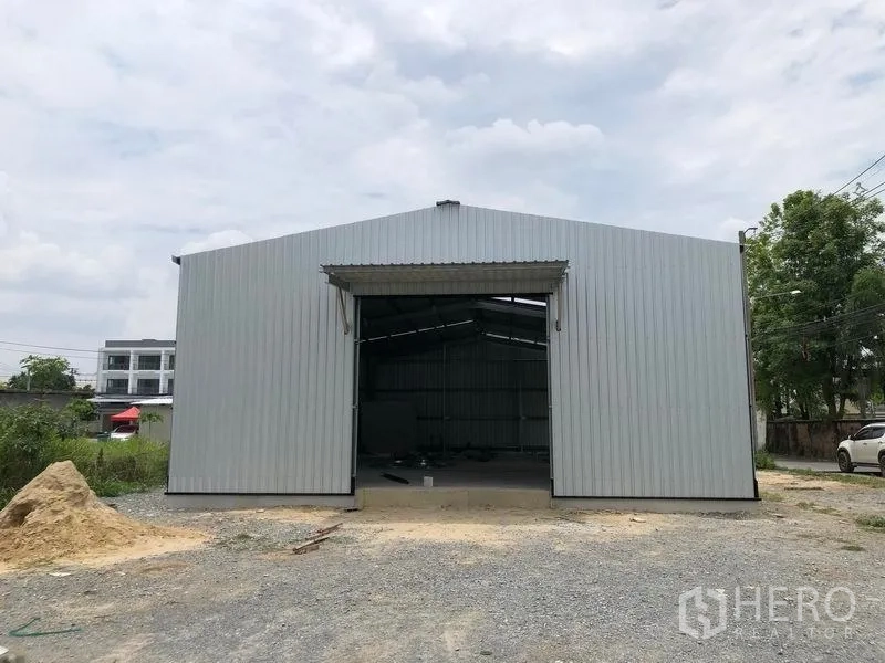 Warehouse for rent in Bang Yai, Nonthaburi - Front elevation of the warehouse showing a wide entry bay and gravel forecourt.