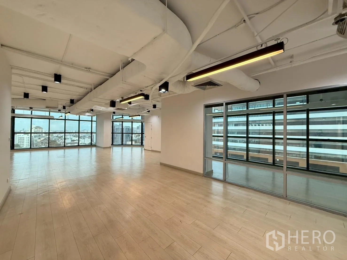 办公室 for rent in Watthana, Bangkok - 转角区域设线性吊灯与通向小房间的玻璃墙。