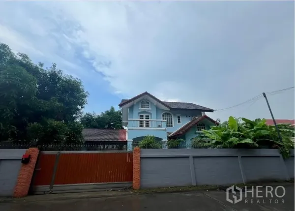 บ้าน ให้เช่าในBang Na, Bangkok - บ้านเดี่ยวสองชั้นสีฟ้า หลังรั้วปูนและประตูไม้บนถนนเงียบสงบ