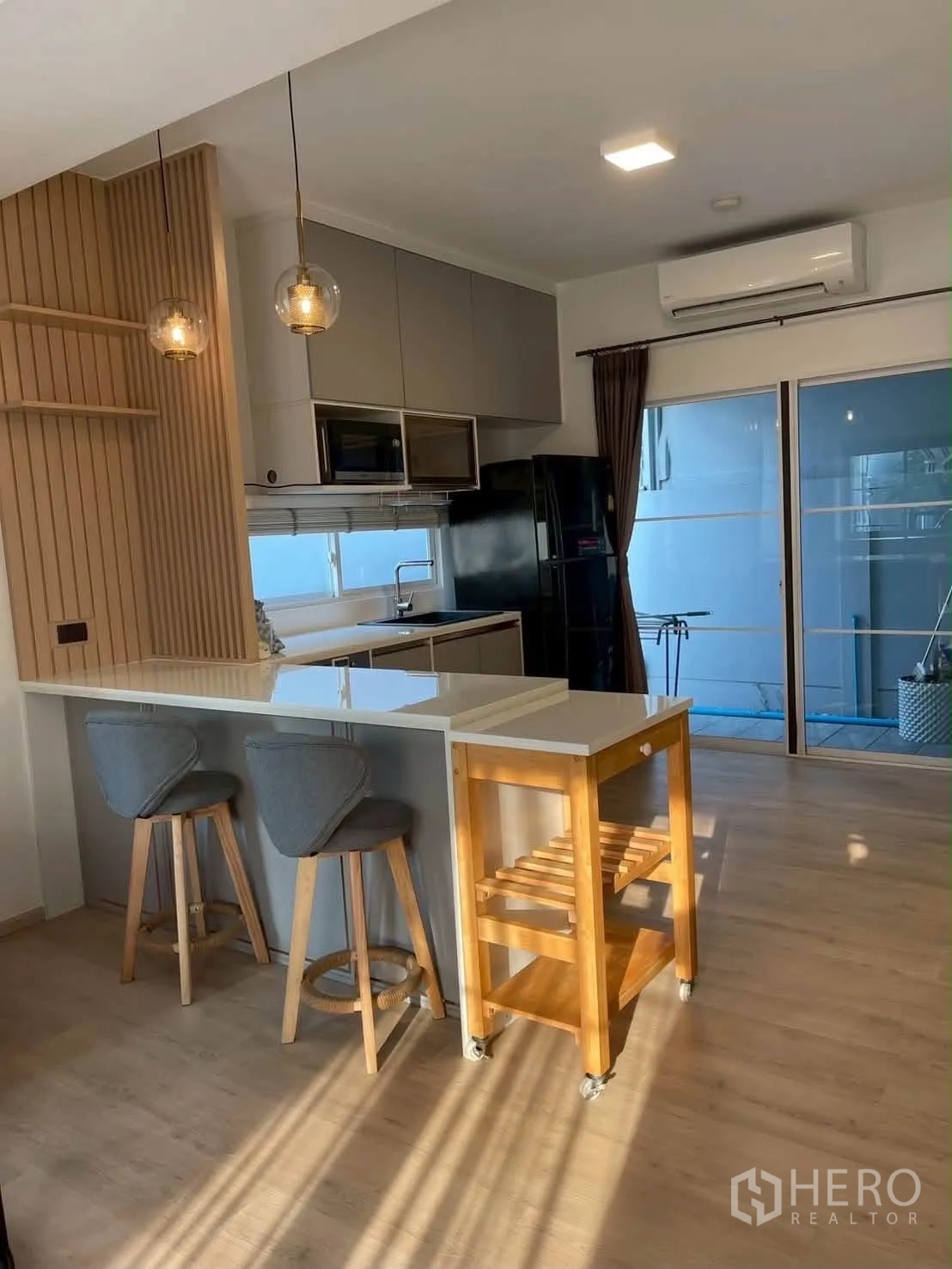 Townhouse for rent in Bang Phli, Samut Prakan - Breakfast bar with pendant lights beside sliding glass doors.