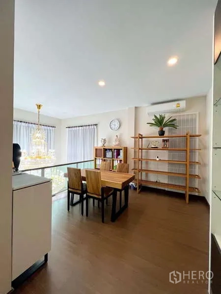 独立式住宅 出售在Prawet, Bangkok - 开放式夹层书房，木质书桌、置物架与玻璃栏板俯瞰吊灯。