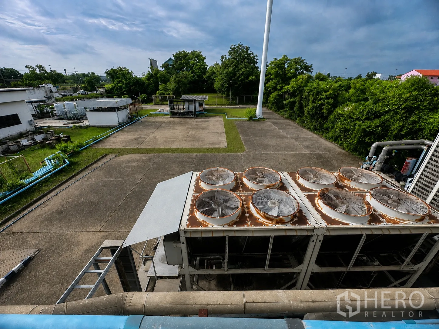 Factory for rent or sale in Wang Noi, Phra Nakhon Si Ayutthaya - Industrial yard view with large chiller units, pipelines, concrete pads, and surrounding greenery.