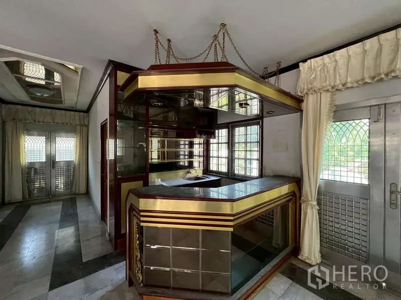 Detached House for rent in Prawet, Bangkok - Indoor bar corner with mirrored shelves and gold‑accent counter beside glass doors.