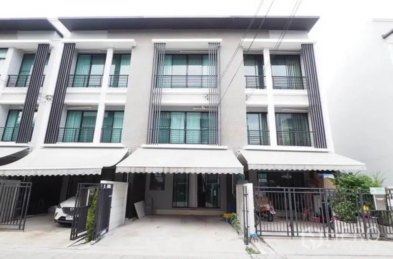 联排别墅 出租或出售在Wang Thonglang, Bangkok - 曼谷旺通朗区三层现代联排别墅外立面，带栅栏车位与遮阳篷。