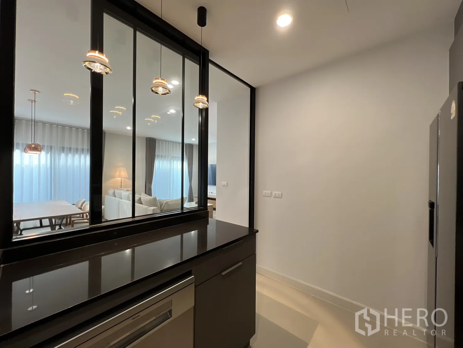 独立式住宅 出租在Prawet, Bangkok - 厨房操作台，吊灯与玻璃隔断。