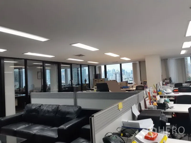 Office Space for sale in Khlong Toei, Bangkok - Bright office floor with cubicles, sofa seating and panoramic skyline windows.
