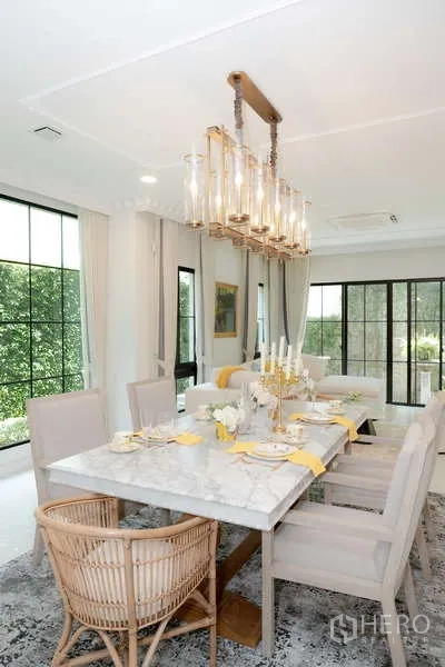 Detached House for rent or sale in Saphan Sung, Bangkok - Elegant dining room featuring a marble table and striking chandelier beside garden views.