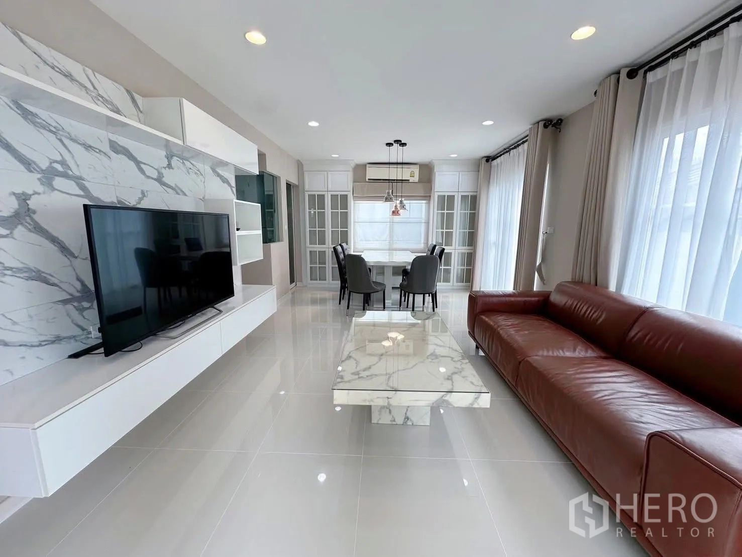 บ้าน ให้เช่าหรือขายในBang Phli, Samut Prakan - มุมยาวของโซนนั่งเล่นเชื่อมรับประทานอาหาร ตู้ทีวีบิวท์อินสีขาวและโต๊ะกลางหินอ่อน