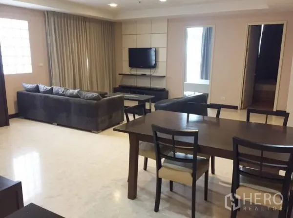 Condominium for rent in Khlong Toei, Bangkok - Another view of the living and dining room showing sofa set and TV.