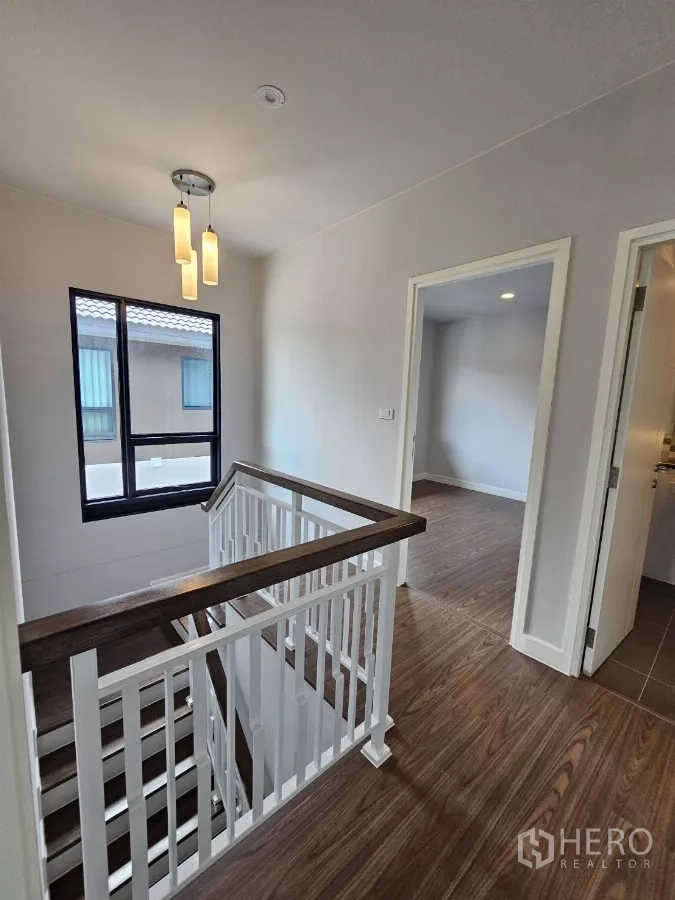 Detached House for sale in Lam Luk Ka, Pathum Thani - Stair landing with pendant lights and access to bedrooms.