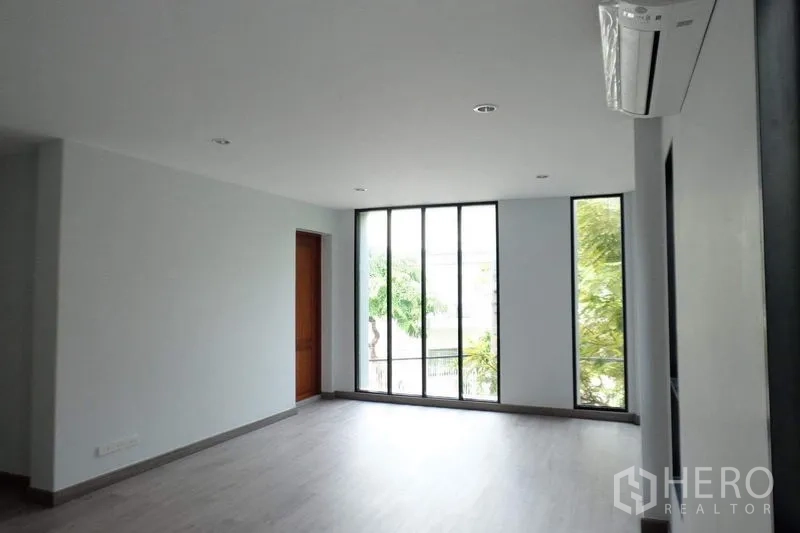 Detached House for sale in Bang Phli, Samut Prakan - Second view of the bright upper room with tall windows and wood-look flooring.