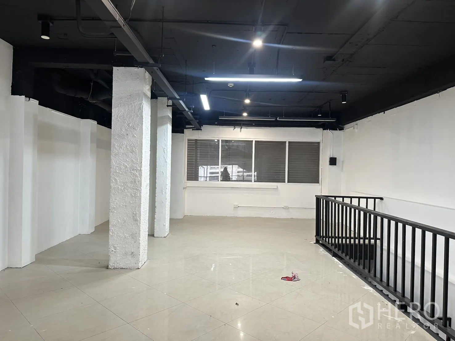 Retail Space for rent in Pathum Wan, Bangkok - Upper level with lighting, pillars, and a metal railing by the stair.