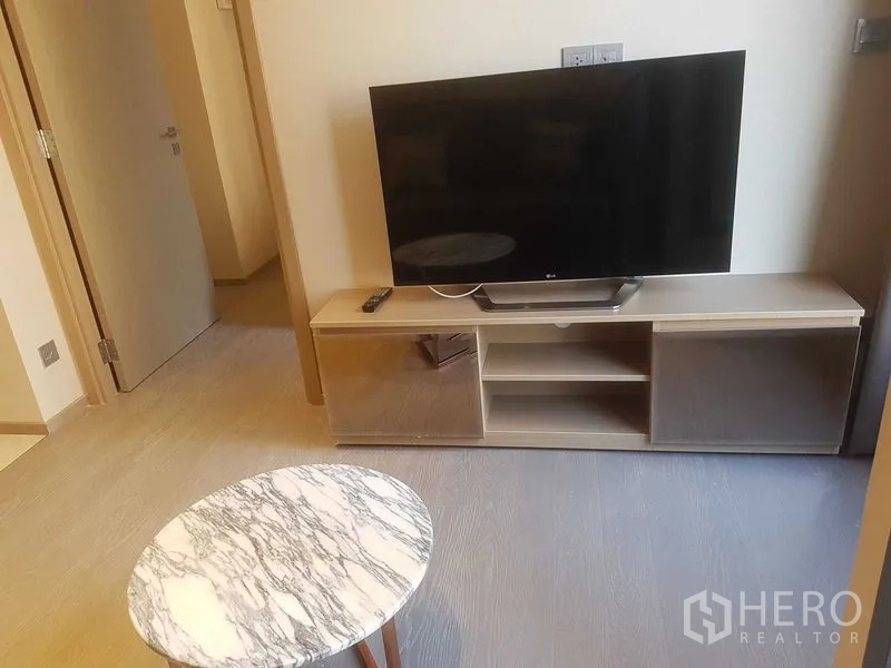 公寓 出租在Watthana, Bangkok - 客厅配大理石茶几、低矮电视柜与木质地板。