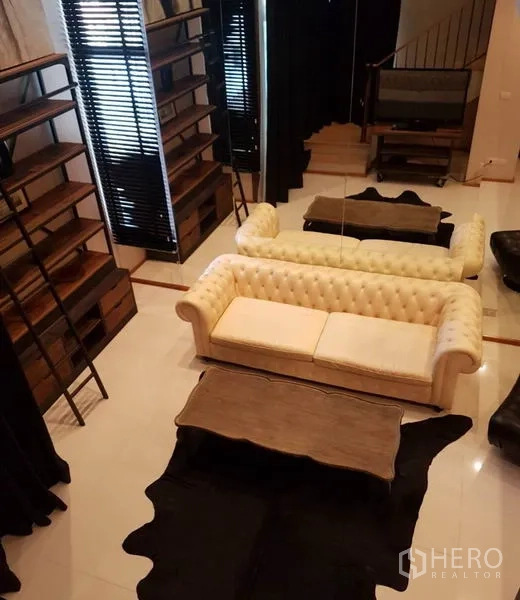 公寓 出租或出售在Khlong Toei, Bangkok - 从夹层俯瞰客厅，可见沙发、置物架与茶几。