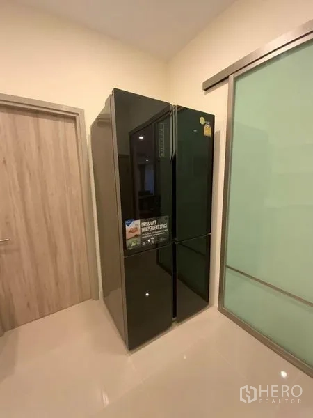 Townhouse for rent in Prawet, Bangkok - Large black side-by-side refrigerator in the utility corner.