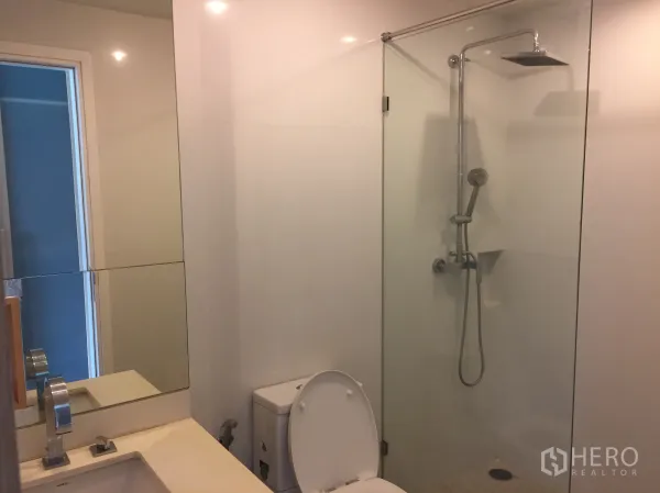 คอนโด ขายในWatthana, Bangkok - ห้องน้ำสไตล์โมเดิร์น พร้อมตู้กระจกอาบน้ำ ฝักบัวเรนชาวเวอร์ และผนังโทนขาว