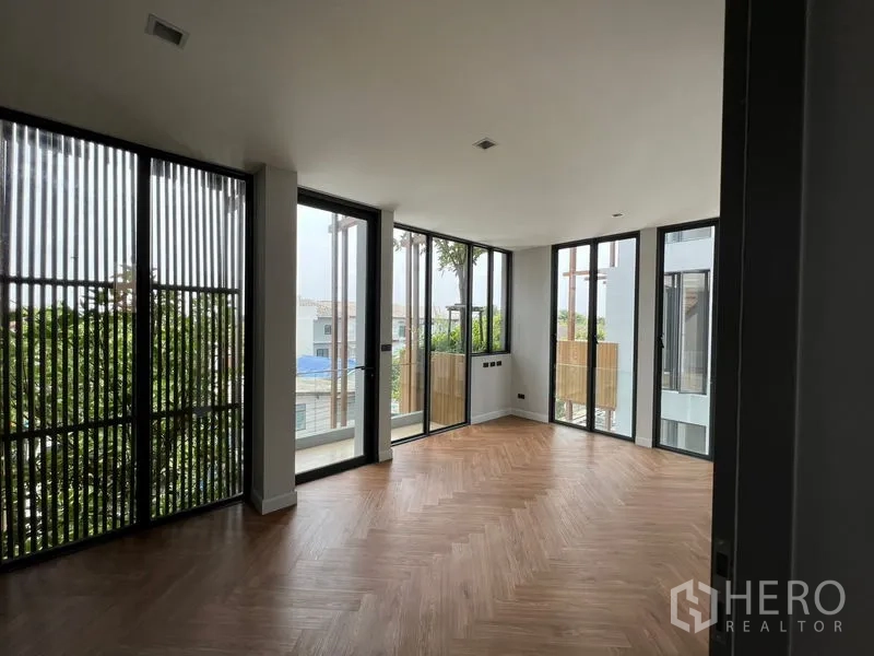 带办公室的家 出售在Wang Thonglang, Bangkok - 转角房间，鱼骨拼木地板，落地推拉门与阳台格栅引入采光。