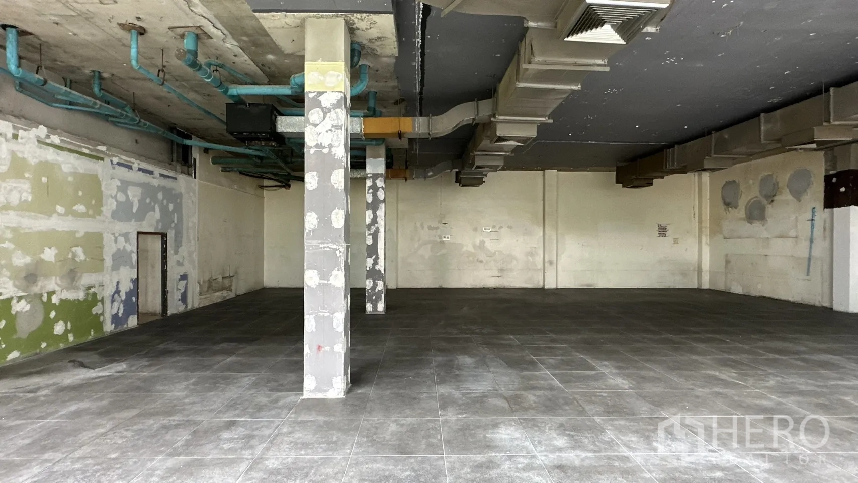 พื้นที่ขายของ for rent in Watthana, Bangkok - งานดักท์และเสาโชว์ในพื้นที่ค้าปลีกโล่งที่ปูกระเบื้อง.