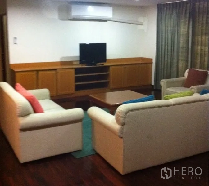 公寓 出租在Watthana, Bangkok - 客厅配奶油色沙发、木质电视柜与木地板。