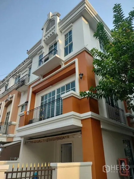 Townhouse for rent in Bueng Kum, Bangkok - Three-storey townhouse exterior with orange and white facade, balconies and large windows.