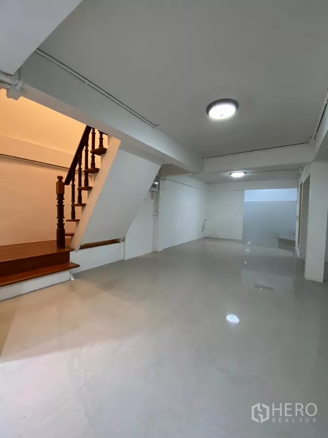 บ้าน ให้เช่าในBang Na, Bangkok - บันไดไม้ติดกับพื้นที่นั่งเล่น โทนสีขาวสะอาดตาและไฟดาวน์ไลท์