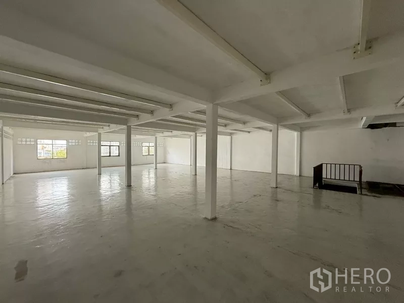 Shophouse for rent - Clean upper-floor hall with white beams and windows on two sides.