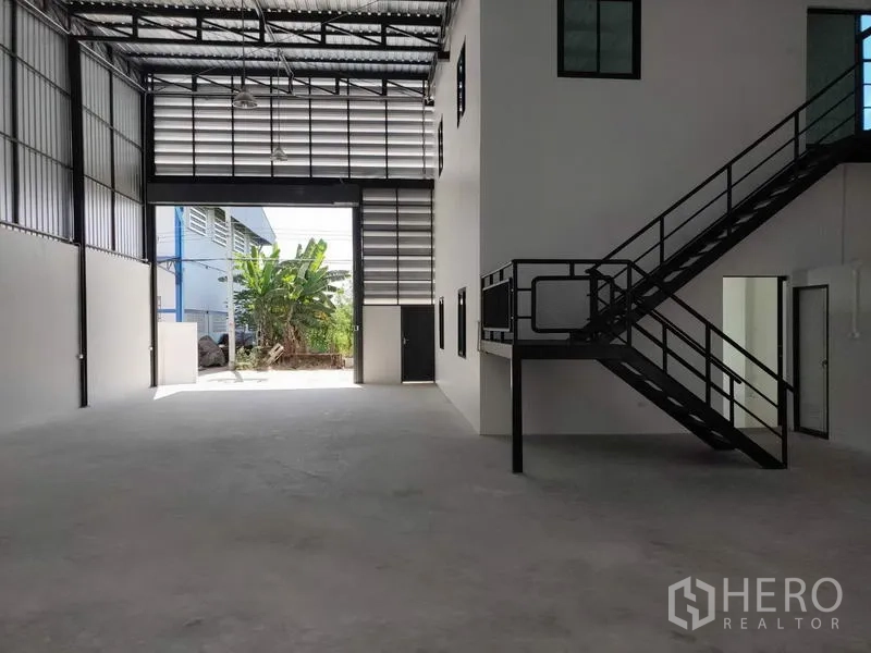 工厂 出租在Lam Luk Ka, Pathum Thani - 开阔仓库空间，超高卷闸门，侧边办公室与通风百叶。