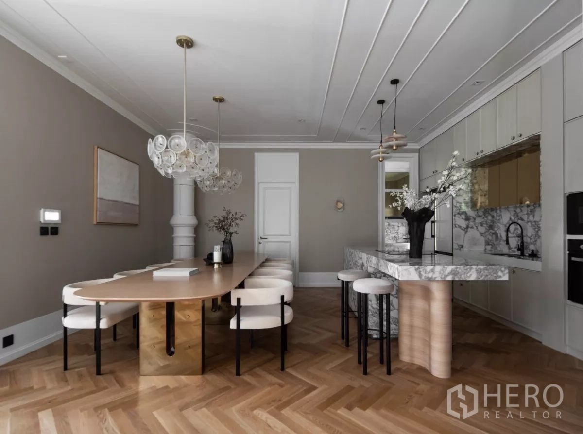 Detached House for rent or sale in Phra Khanong, Bangkok - Elegant dining area and marble kitchen island with pendant lighting and built-in cabinetry.