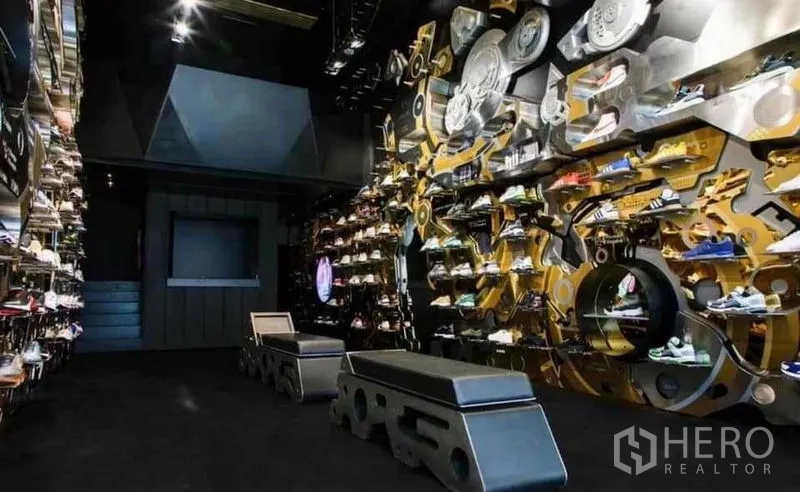 Shophouse for rent in Khlong Toei, Bangkok - Spacious retail showroom with benches and mechanical-themed feature walls.