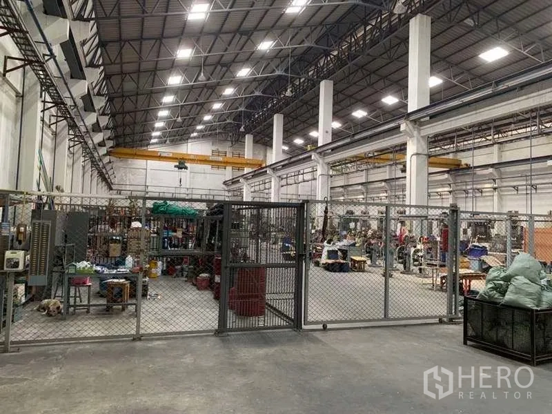 Factory for rent in Samut Prakan - Secure fenced zone inside the warehouse used for materials and equipment storage.