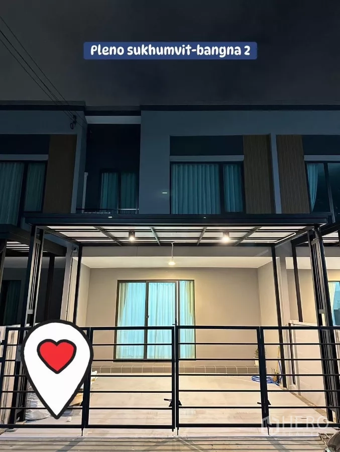 Townhouse for rent in Bang Phli, Samut Prakan - Night view of the Pleno Sukhumvit–Bangna 2 townhouse facade with a covered double carport and metal gate.