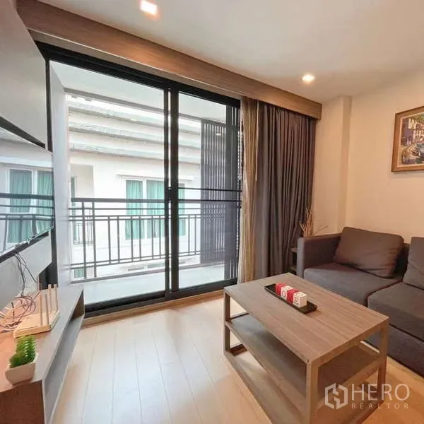Condominium for rent - Bright living room with sliding glass doors opening to a balcony in a Thonglor condo.