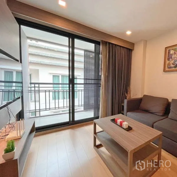Condominium for rent - Bright living room with sliding glass doors opening to a balcony in a Thonglor condo.