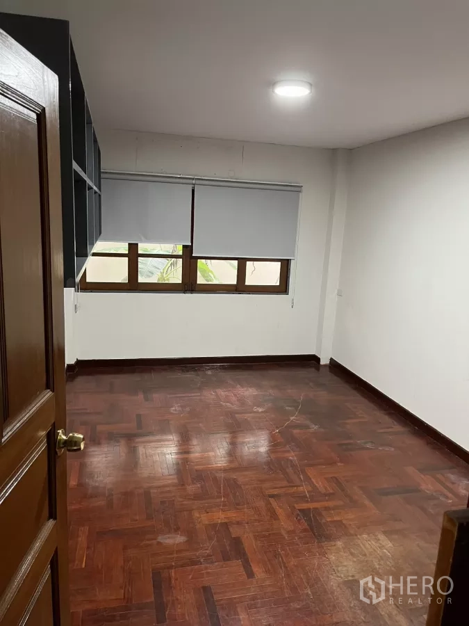 Detached House for rent in Watthana, Bangkok - Bedroom with parquet flooring, roller blinds and low horizontal windows.