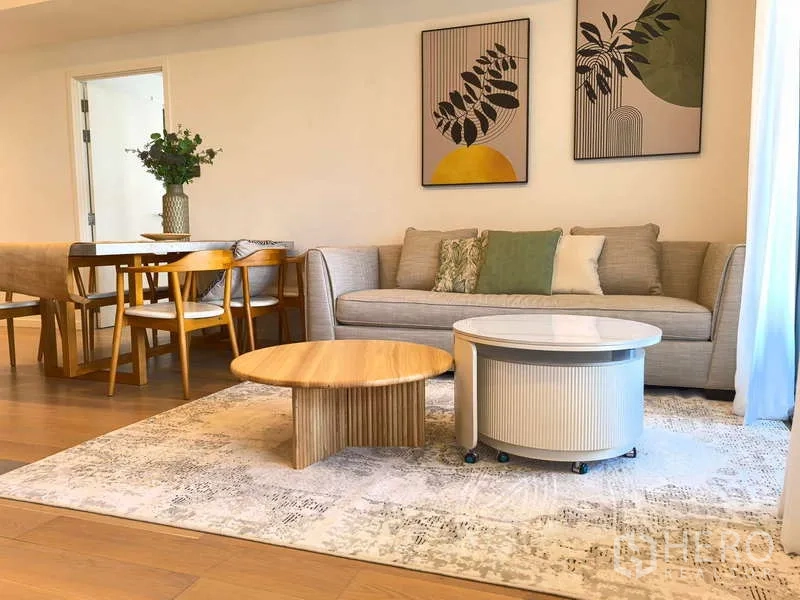 Apartment for rent - Living room featuring neutral sofa, round nesting coffee tables and dining set.
