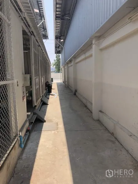 Factory for rent in Khlong Luang, Pathum Thani - Side corridor beside equipment area and neighboring building.