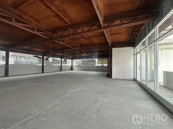 Retail Space for rent in Watthana, Bangkok - Spacious retail unit with sliding glass entrance and panoramic windows along the facade.