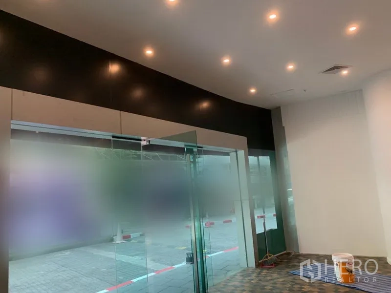 Retail Space for rent in Khlong Toei, Bangkok - Interior view showing glass entrance, recessed ceiling lights and tiled floor.