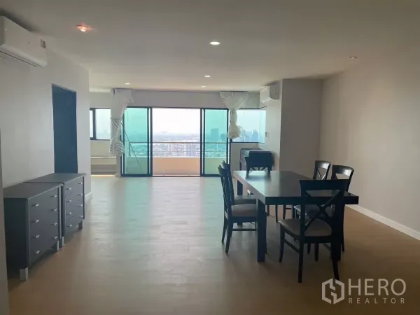 Condominium for rent in Sathon, Bangkok - Dining area facing a large balcony with panoramic city views.